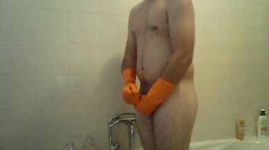 Sega con guanti di gomma arancioni